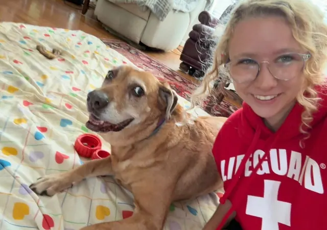 The walker with a smiling senior dog on a blanket